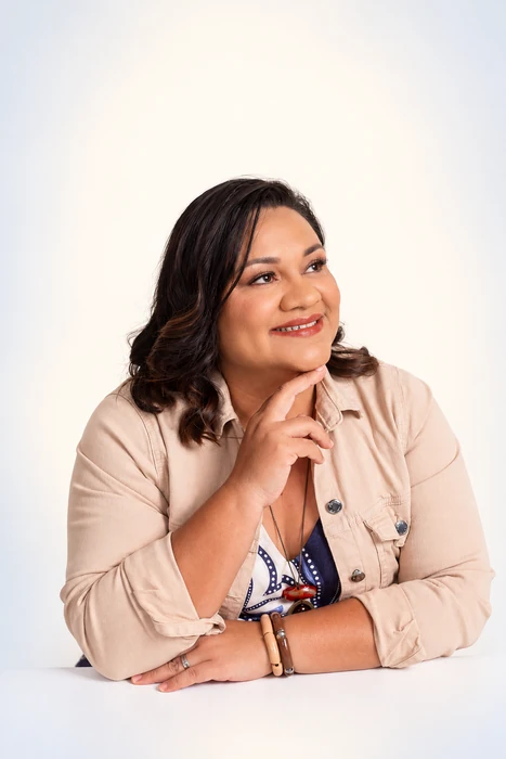 Joceline Barreto, de blazer bege, olhando para o lado