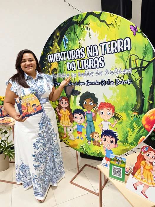 Joceline com seu livro diante do painel do lançamento