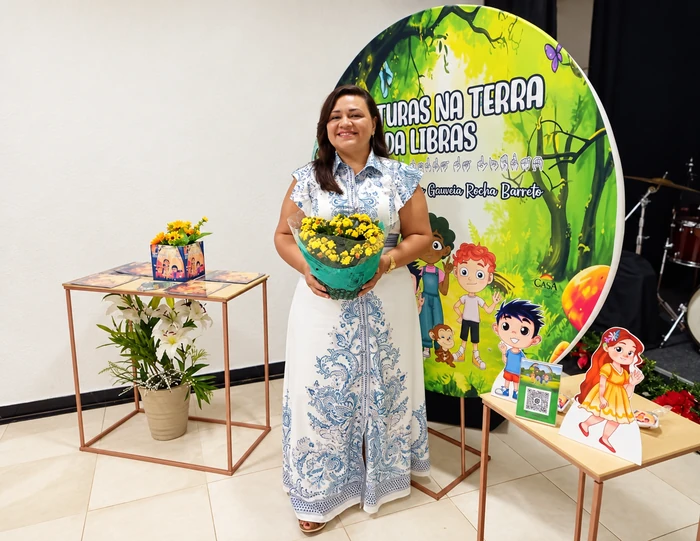 Joceline segurando flores no lançamento do seu livro